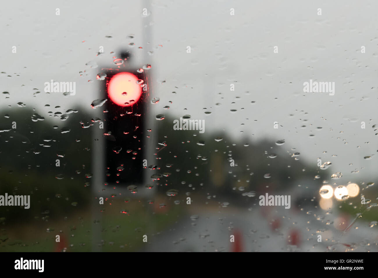 Feux de circulation par le biais de pare-brise et de la pluie Banque D'Images