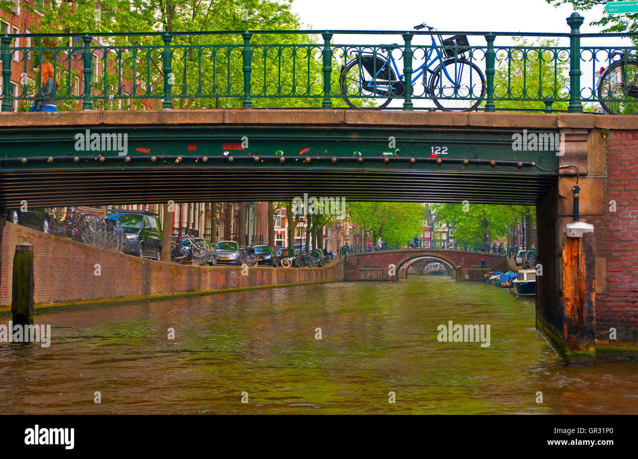 Un vélo garé sur un pont sur un canal à Amsterdam, Hollande Banque D'Images