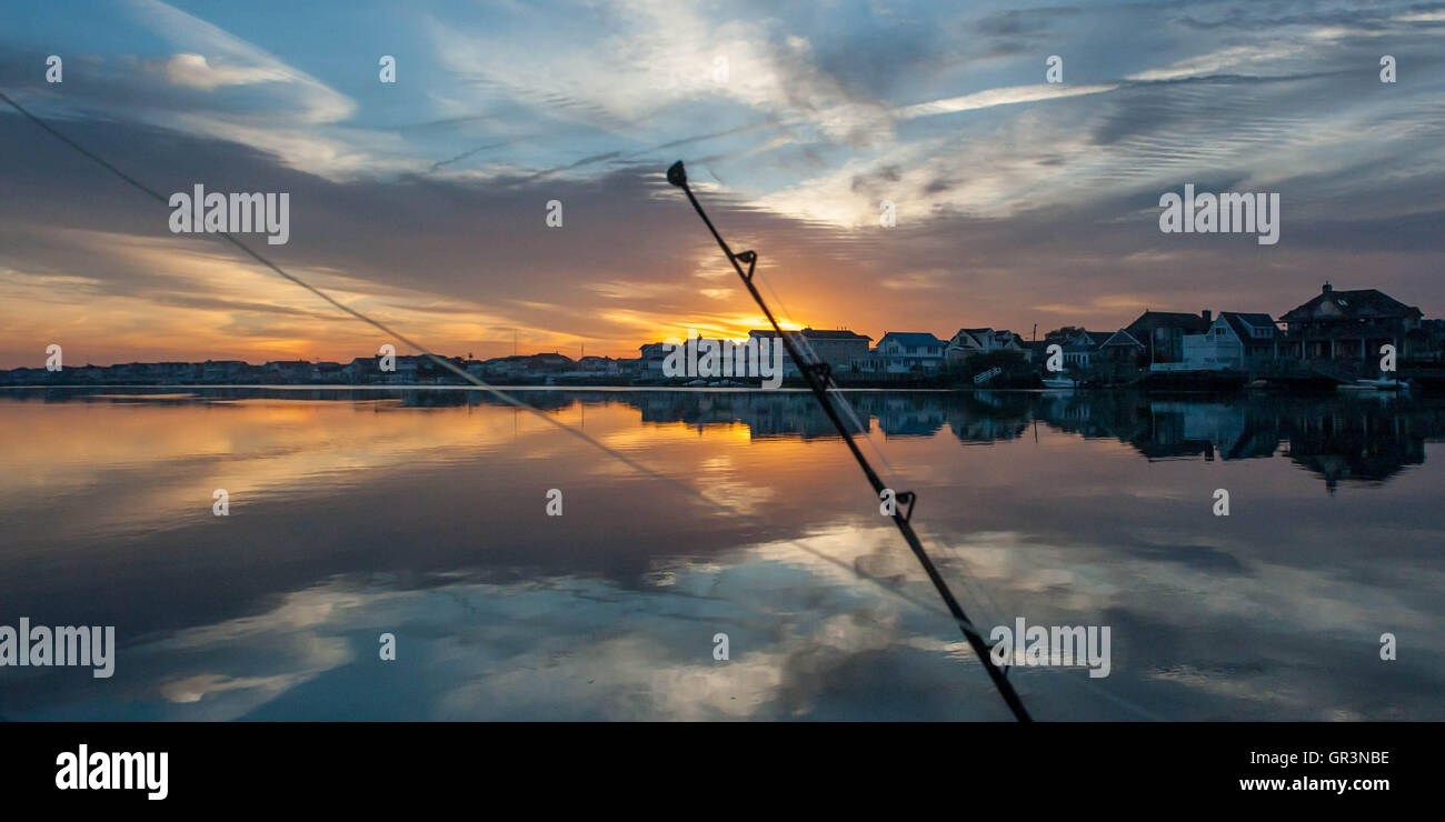 Une canne à pêche se profile au lever du soleil à Stone Harbor, New Jersey, United States | coucher du soleil sur la baie de Plaisance | pêche en haute mer Banque D'Images