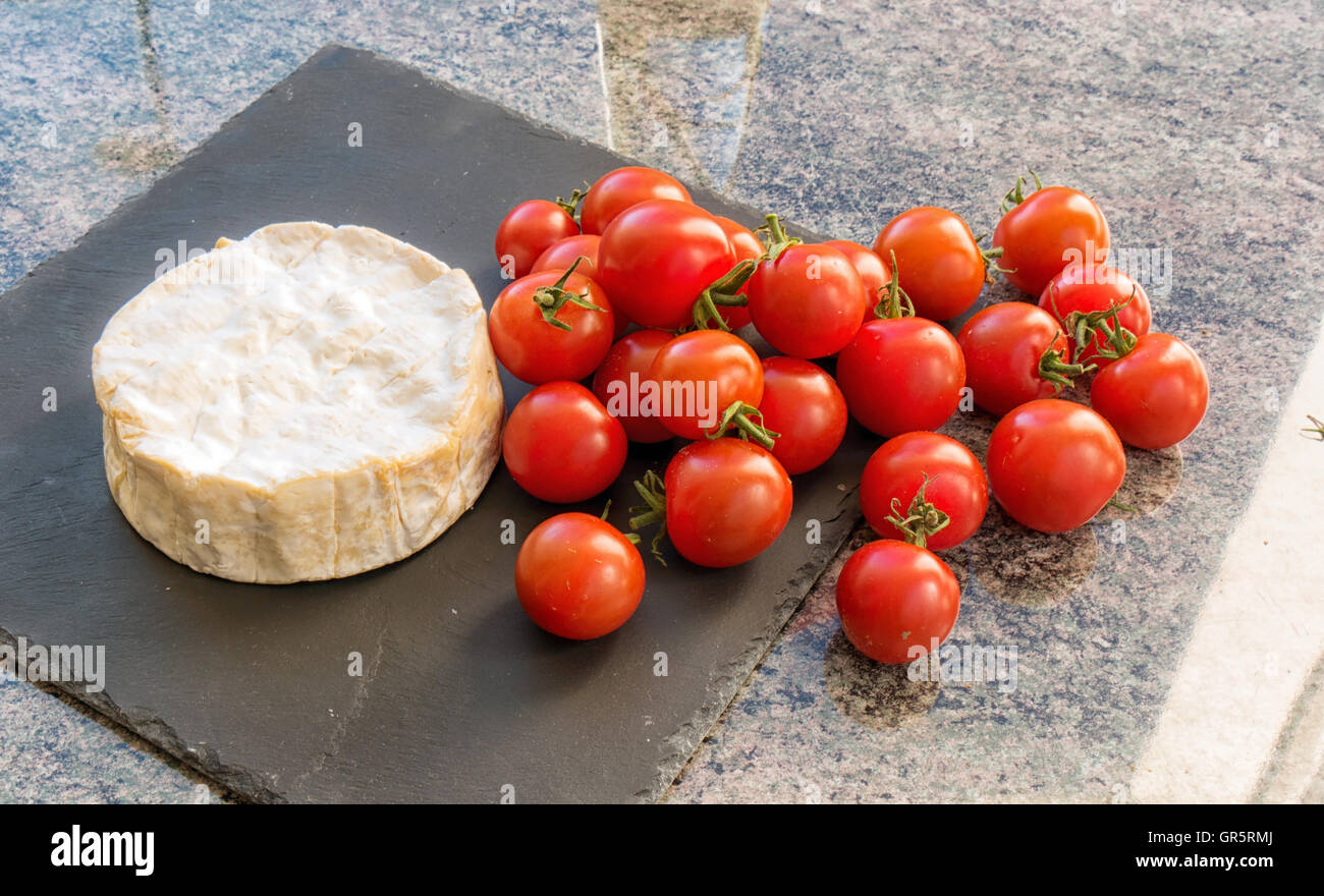 Un Camembert de Normandie avec tomates cerises Banque D'Images