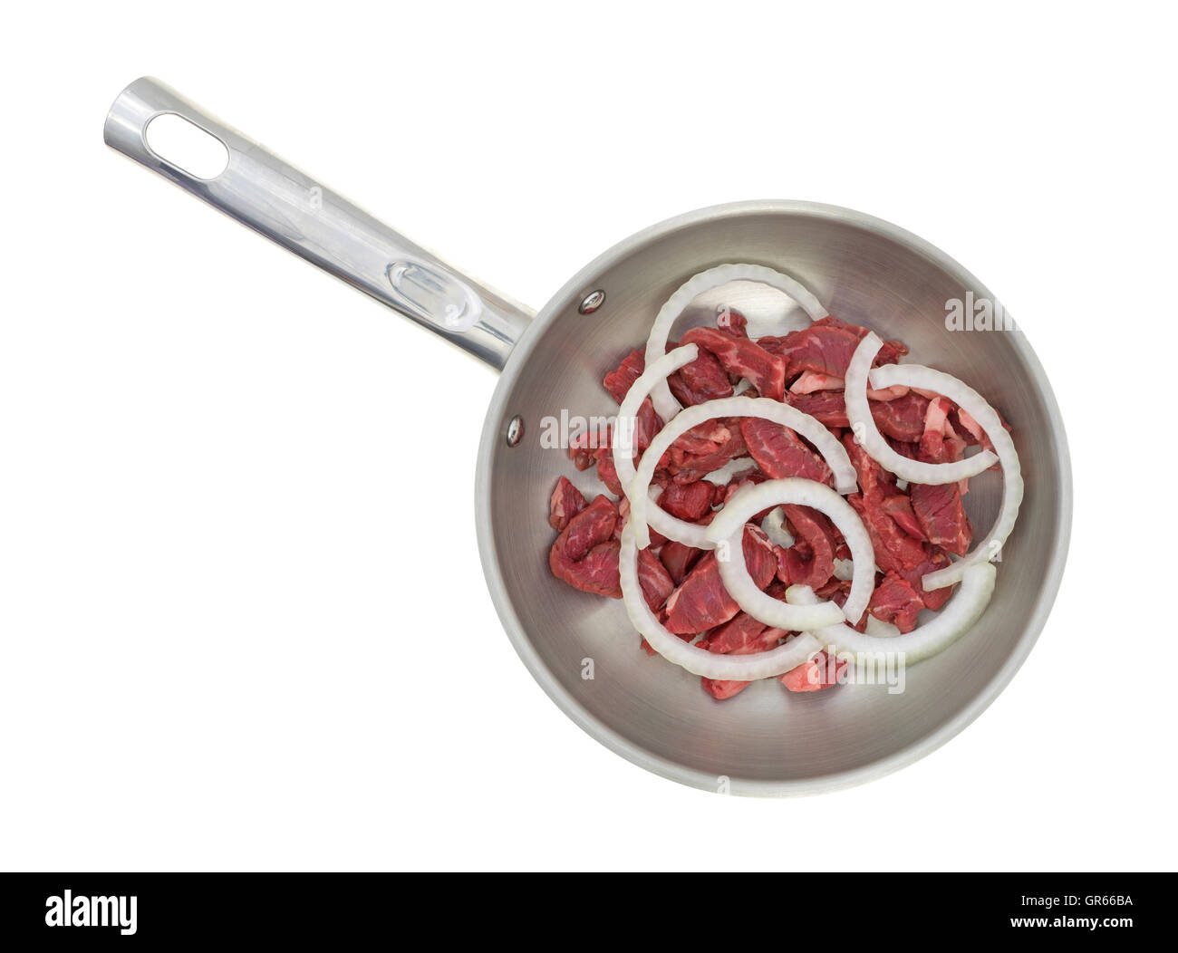 Vue de dessus de tranches de steak avec des oignons dans une poêle en métal sur un fond blanc. Banque D'Images