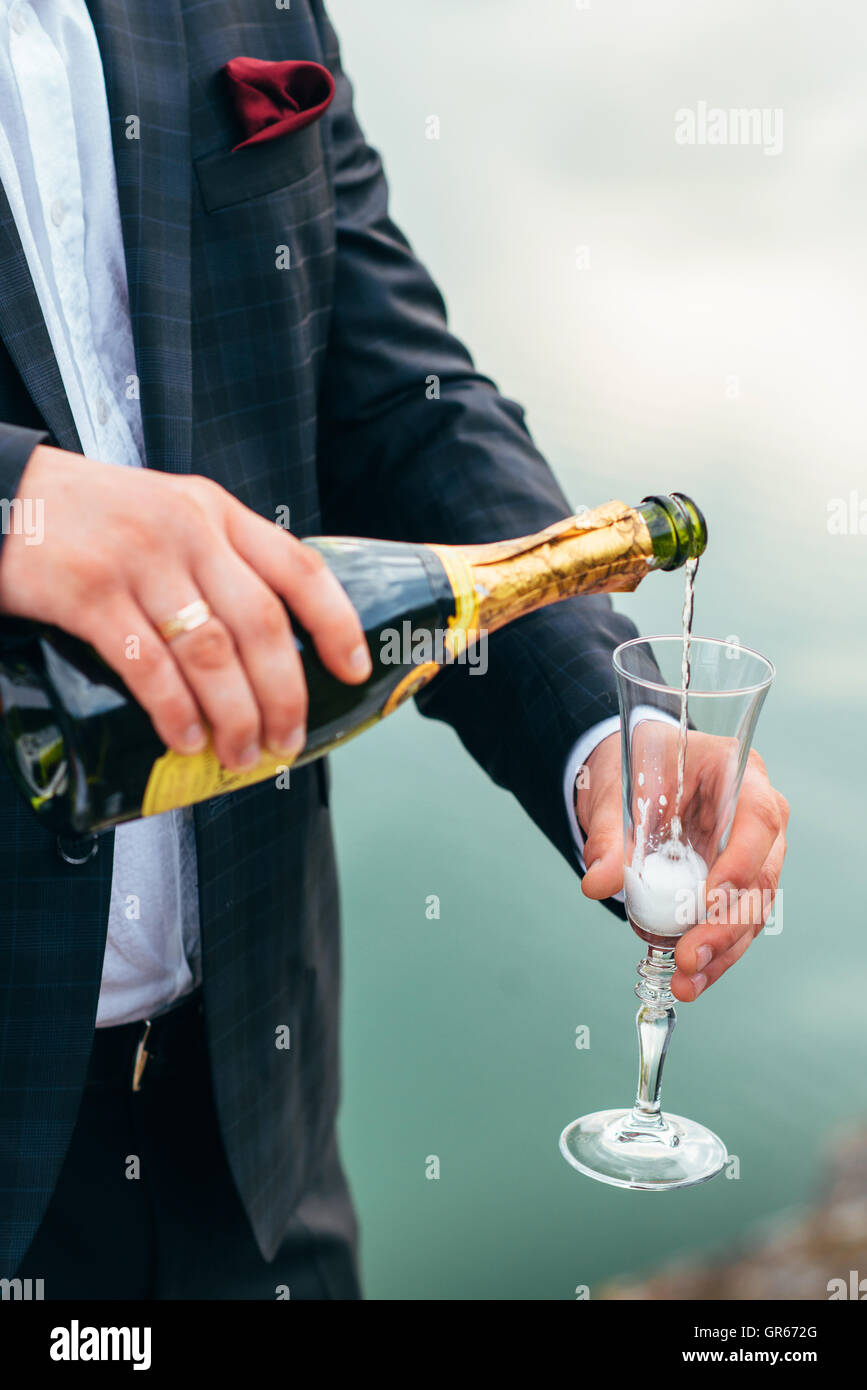 Le couple a célébré leur mariage avec une bouteille de champagne et des verres dans les mains Banque D'Images Le couple a célébré leur mariage avec une bouteille de champagne et des verres dans les mains Banque D'Images