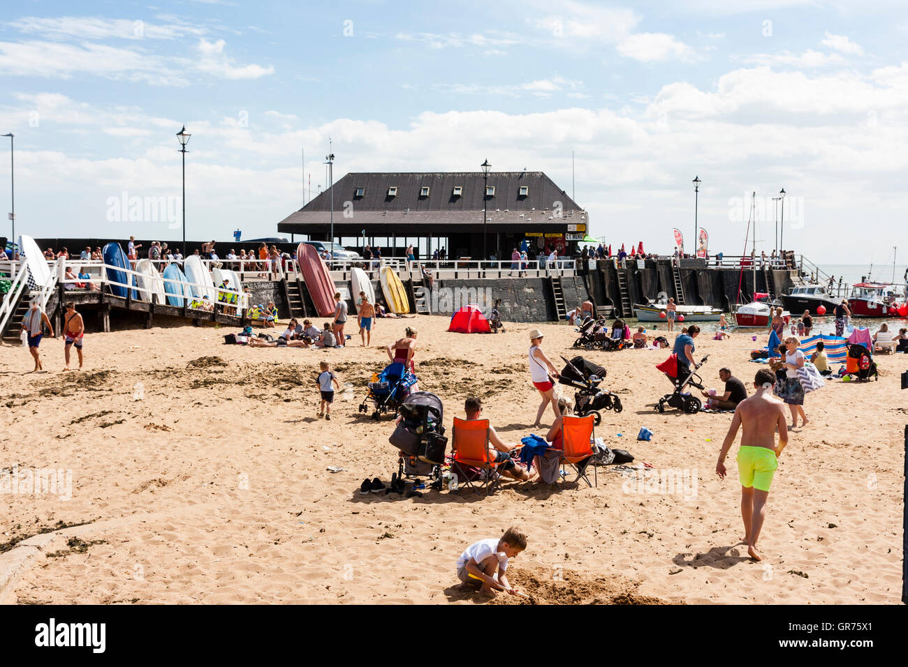 Broadstairs resort town en UK, la plage principale avec petit port à une extrémité. chaude journée d'été avec beaucoup de personnes et les familles sur la plage de soleil. Banque D'Images