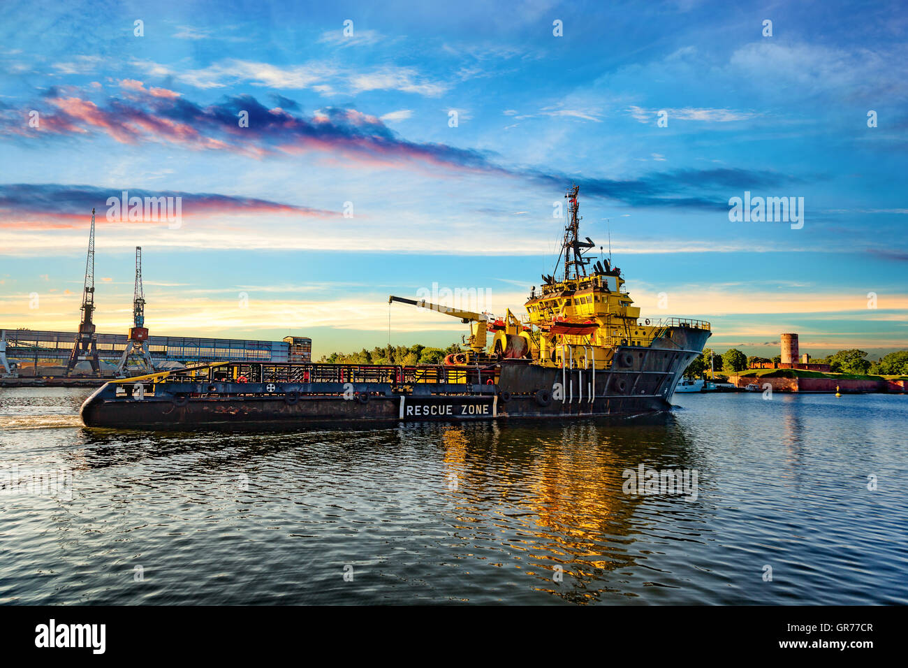 Tug boat au lever du soleil de venir au port. Banque D'Images