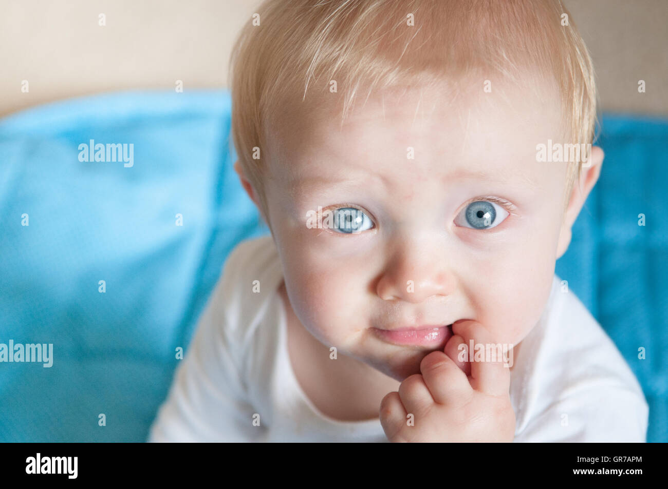 Bébé garçon aux yeux bleus et aux cheveux blonds à directement à l'appareil photo Banque D'Images