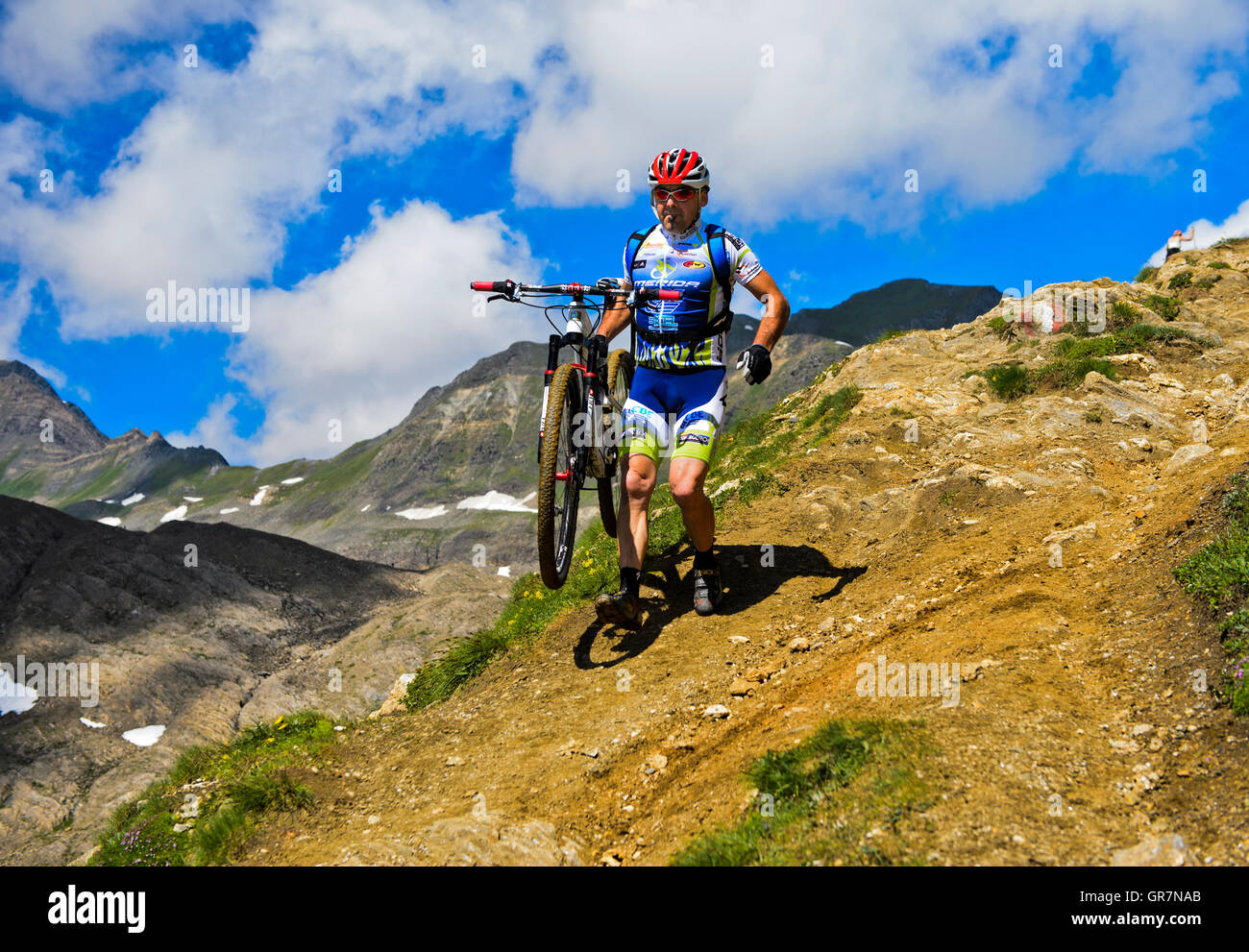 Mountainbiker porte le vélo sur un chemin raide près de la Corno Gries Refuge, Tessin, Suisse Banque D'Images