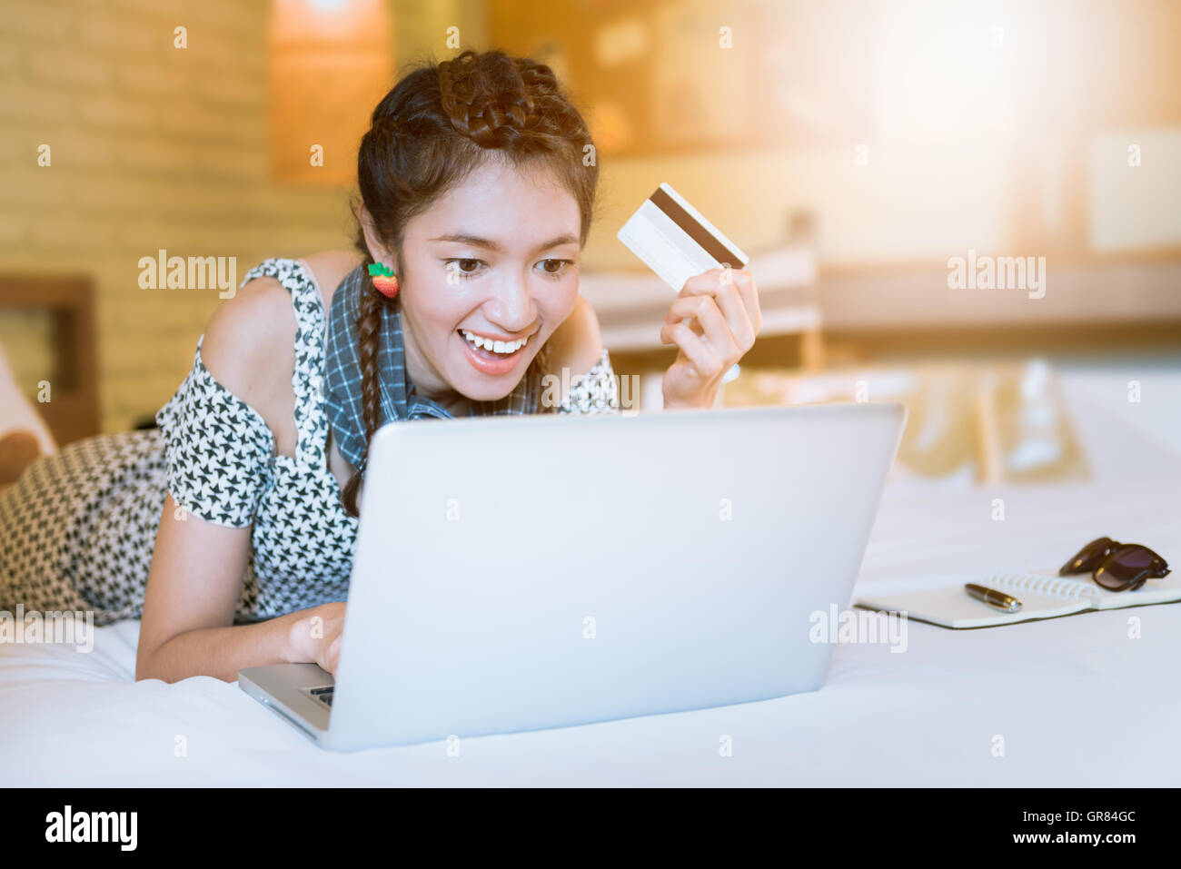 Passe de l'asian woman doing online shopping couché dans la chambre Banque D'Images