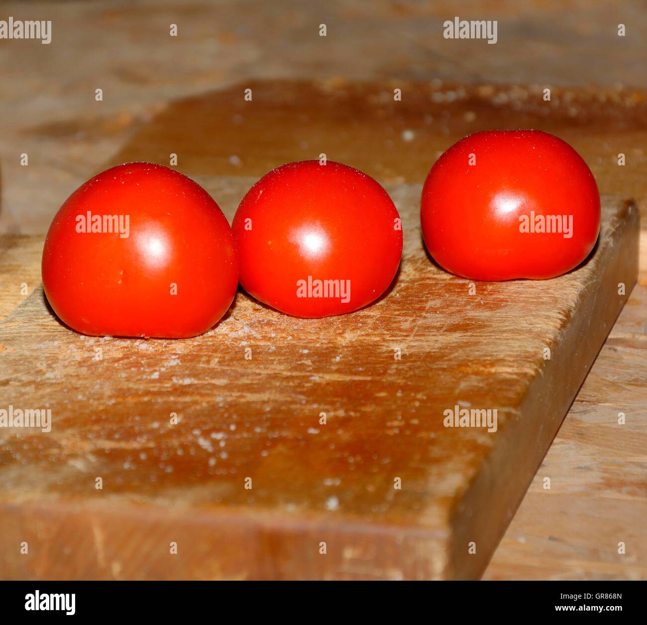 Trois Tomates, Solanum lycopersicum, sur une planche à découper, Salzbroeseln Banque D'Images