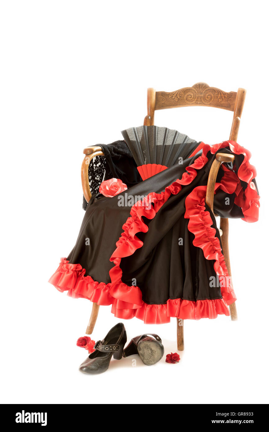 Verticalement sur le vêtement et chaussures pour la danse flamenco sont couchés sur une chaise en bois vintage. Tout est sur le fond blanc Banque D'Images