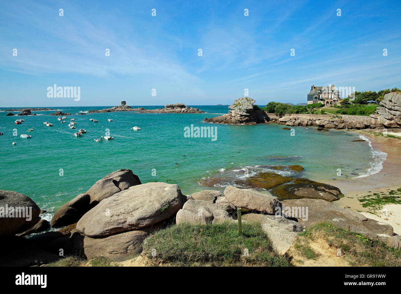 Roches dans une baie près de Tregastel et bateaux, Côte de Granit Rose, Bretagne Banque D'Images