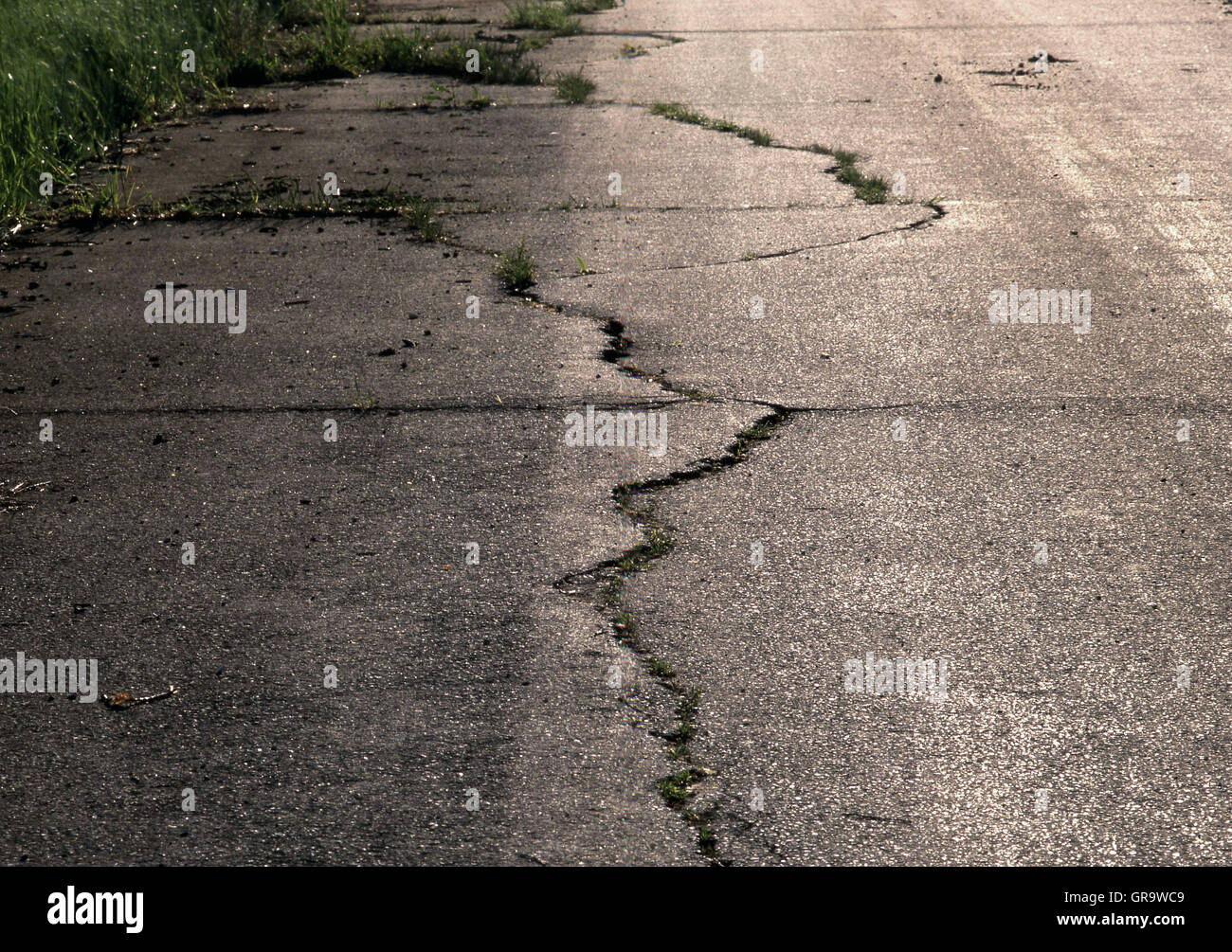 Fissures dans une route de rétro-éclairage Banque D'Images