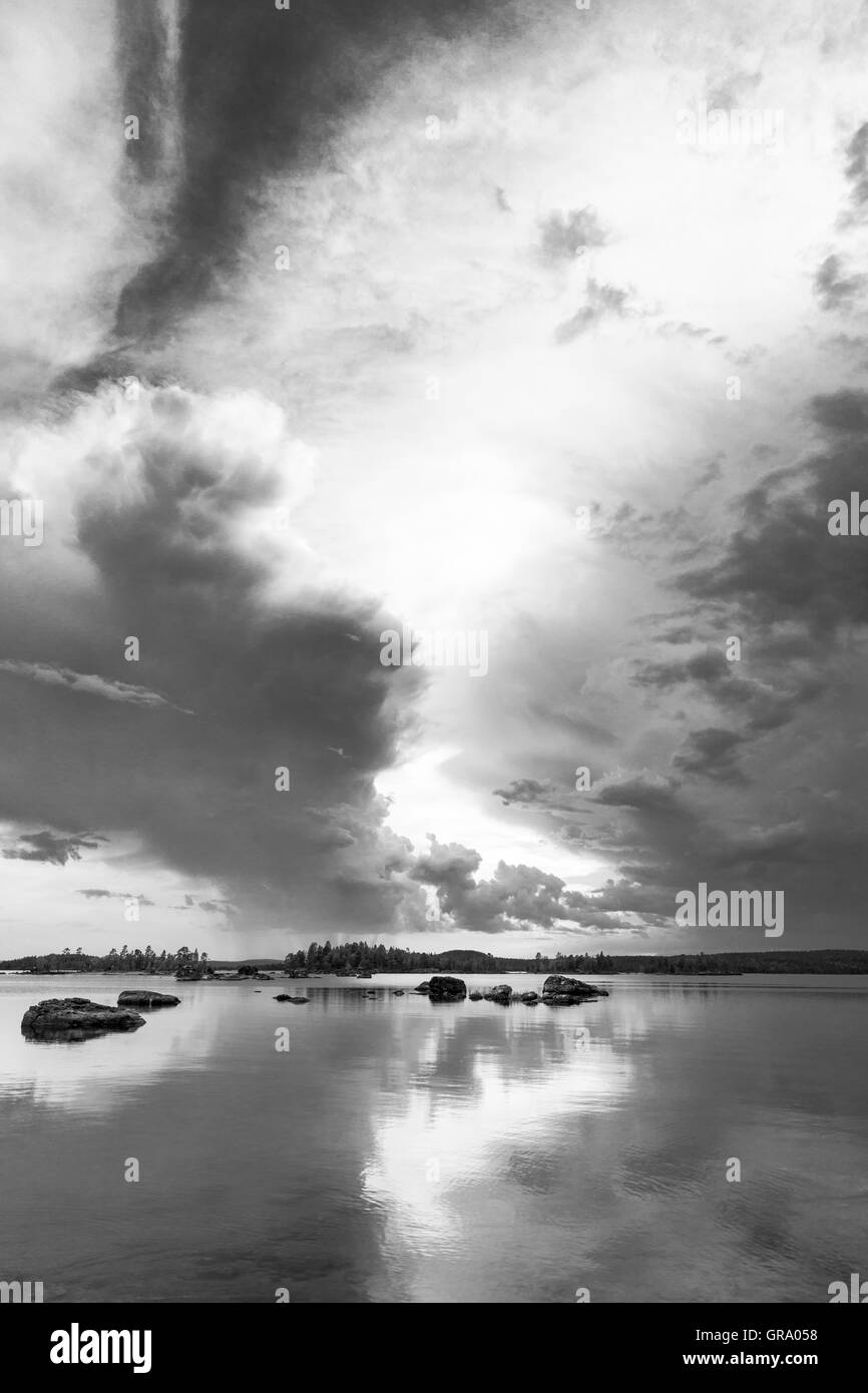 Photo en noir et blanc des réflexions des nuages spectaculaires dans le nord du lac Inari en Laponie finlandaise Banque D'Images