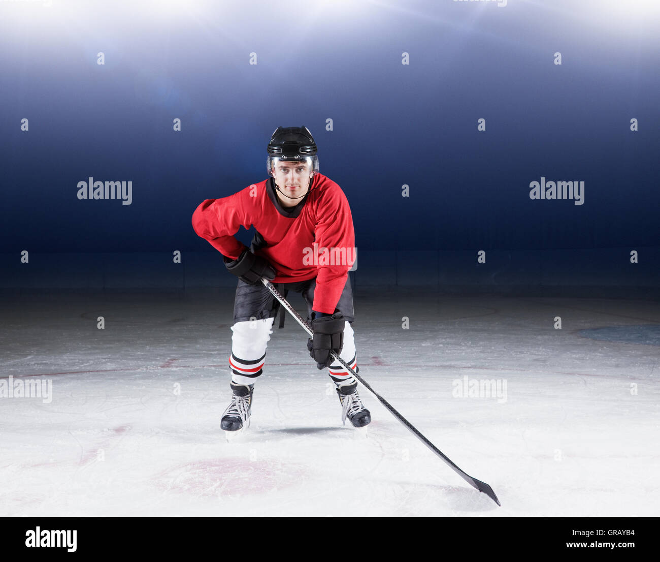 Portrait déterminé le joueur de hockey sur glace en uniforme rouge Banque D'Images