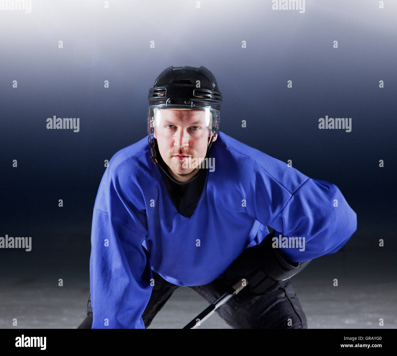 Portrait déterminé le joueur de hockey sur glace en uniforme bleu Banque D'Images