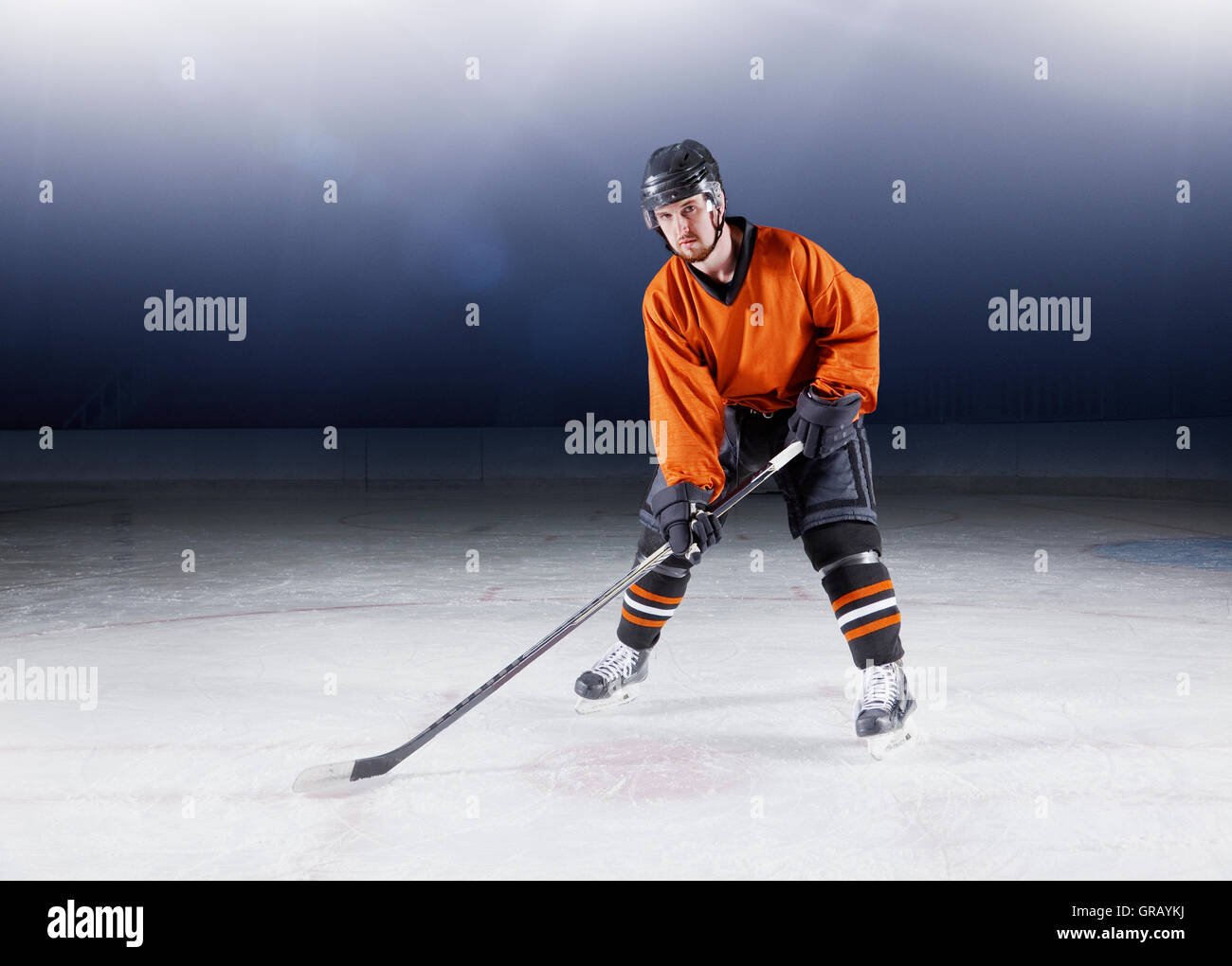 Portrait confiant joueur de hockey sur glace en uniforme orange Banque D'Images