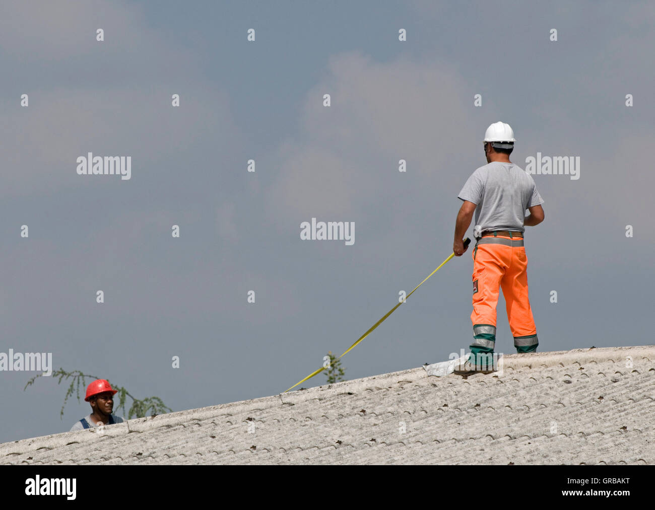 Construction Worker Wearing Helmet sur toit de maison Banque D'Images