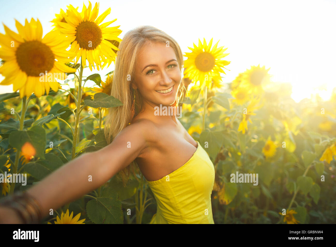 Portrait d'art d'une belle femme avec des tournesols dans le coucher du soleil Banque D'Images