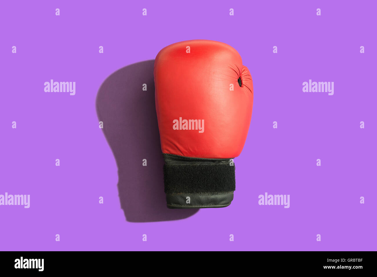 Gant de boxe avec l'ombre sur fond violet Banque D'Images