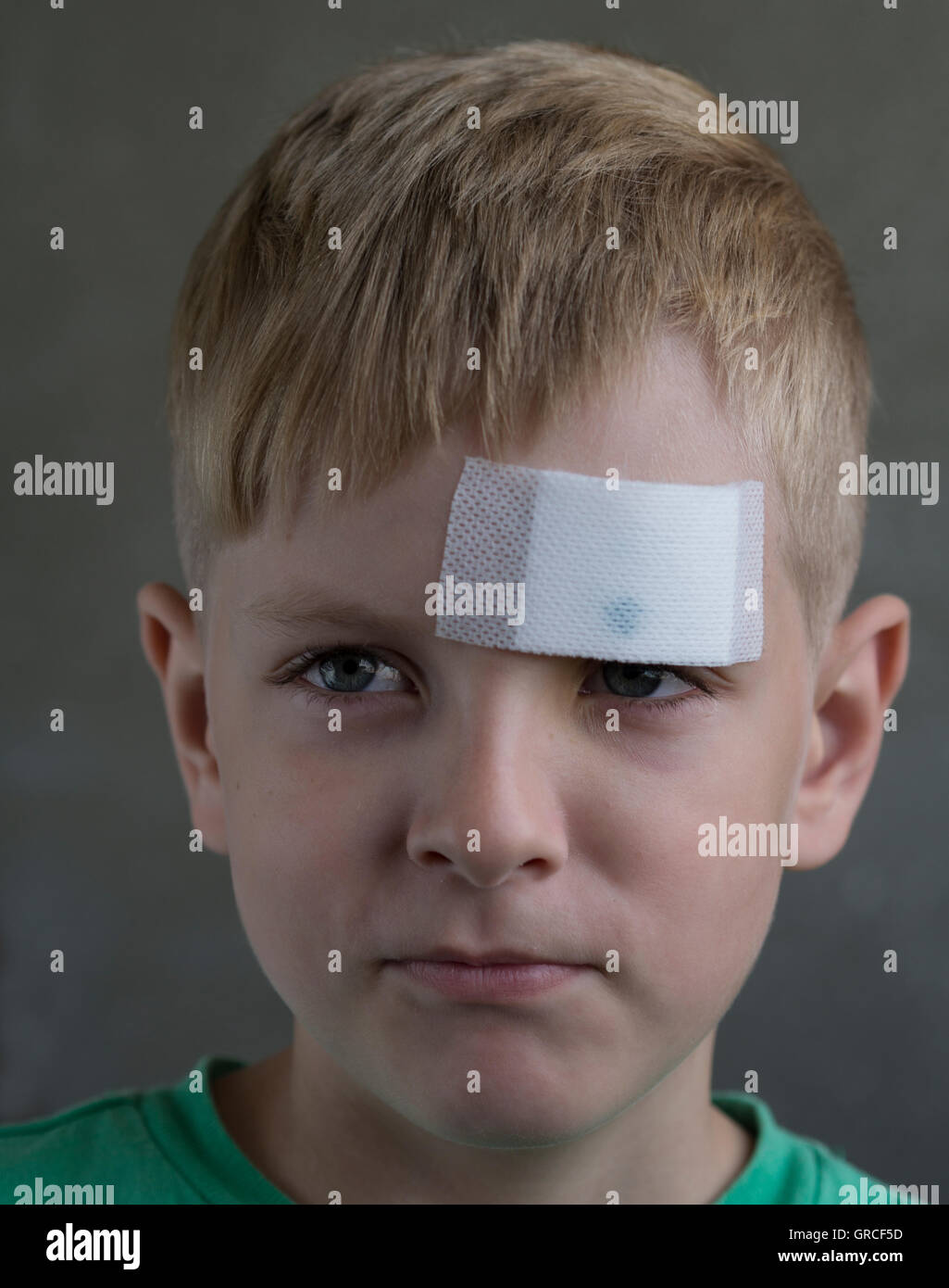 Young boy avec une blessure sur son front en plâtre Banque D'Images