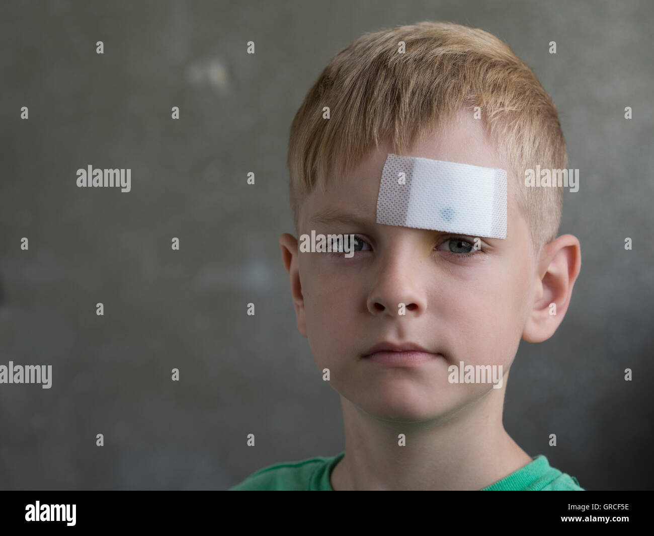 Young boy avec une blessure sur son front en plâtre Banque D'Images