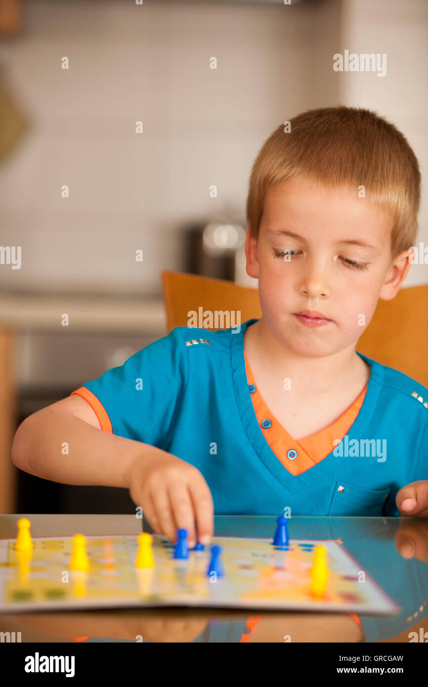 Boy playing ludo jeu à la maison. Banque D'Images