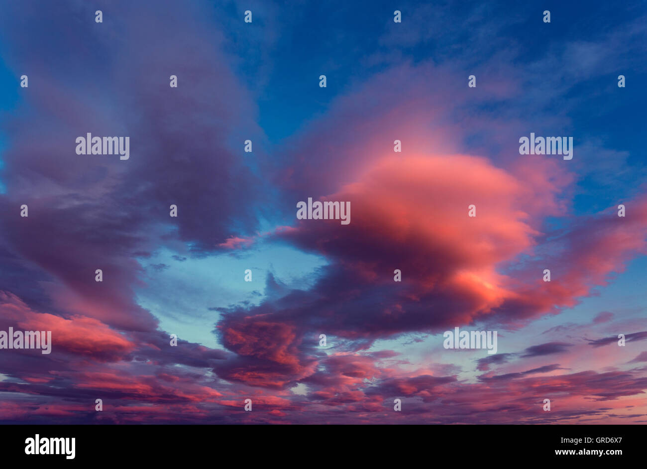 Coucher Soleil nuages rouges sur fond de ciel bleu Banque D'Images