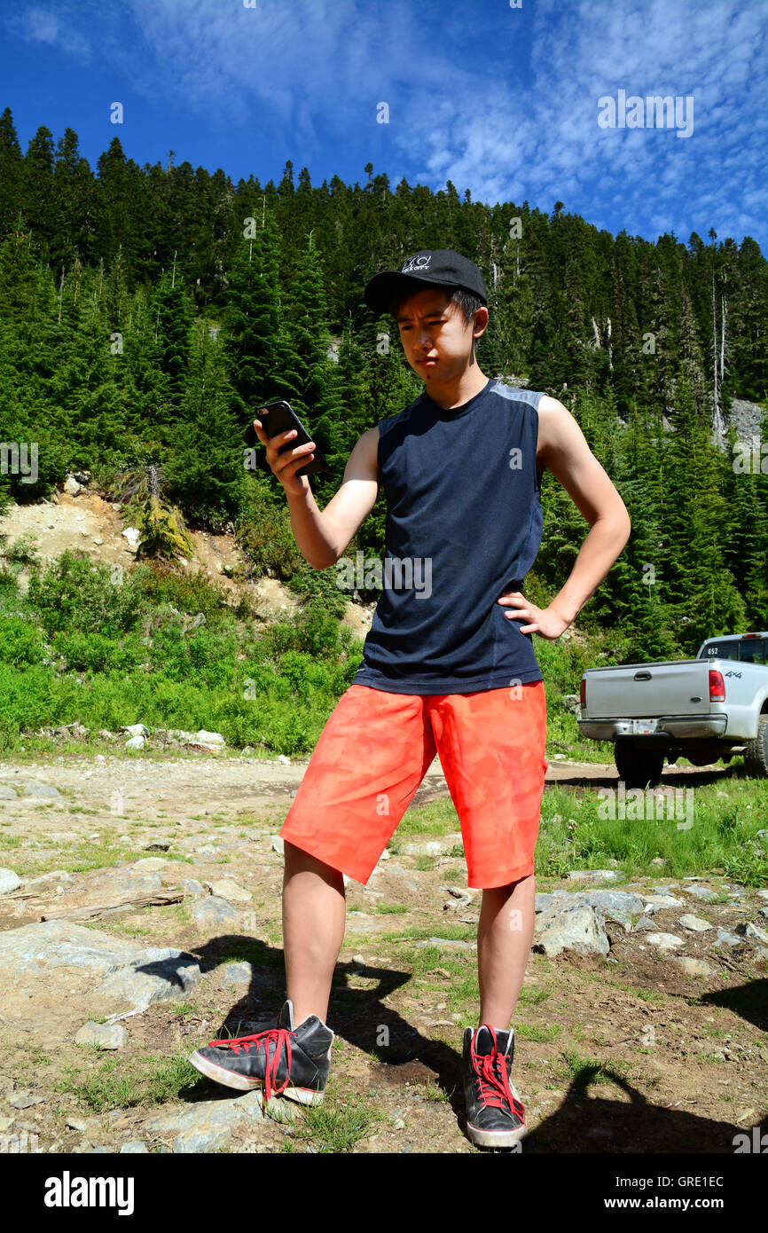 GenY homme prend dans la nature Photo Selfies Smartphone iPhone6 via la technologie Onroute sentier de gravier de Brandywine Meadows Whistler, C.-B. Banque D'Images