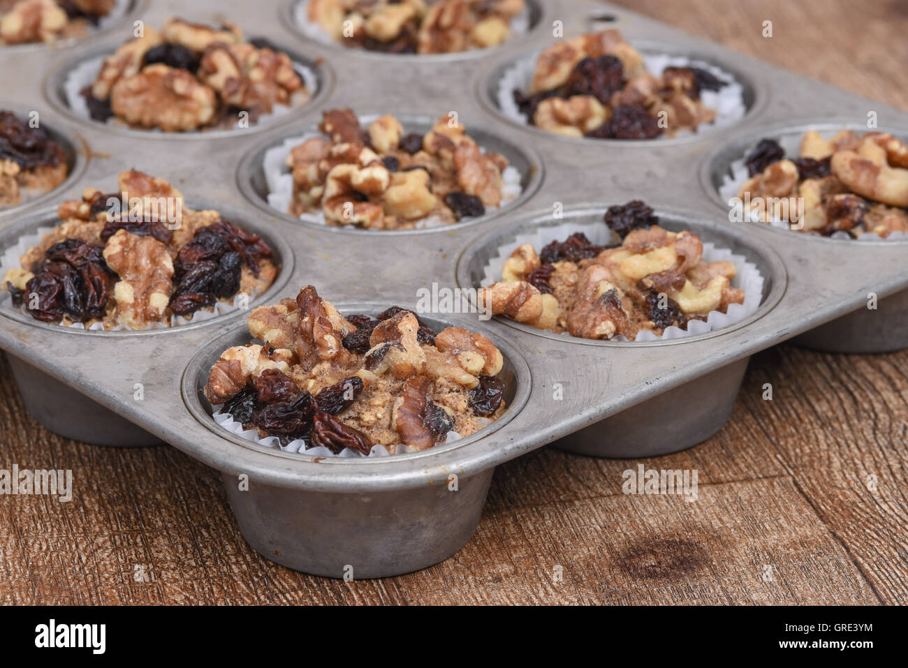 Muffins aux raisins secs et noix dans un vieux moule à muffins de mode Banque D'Images