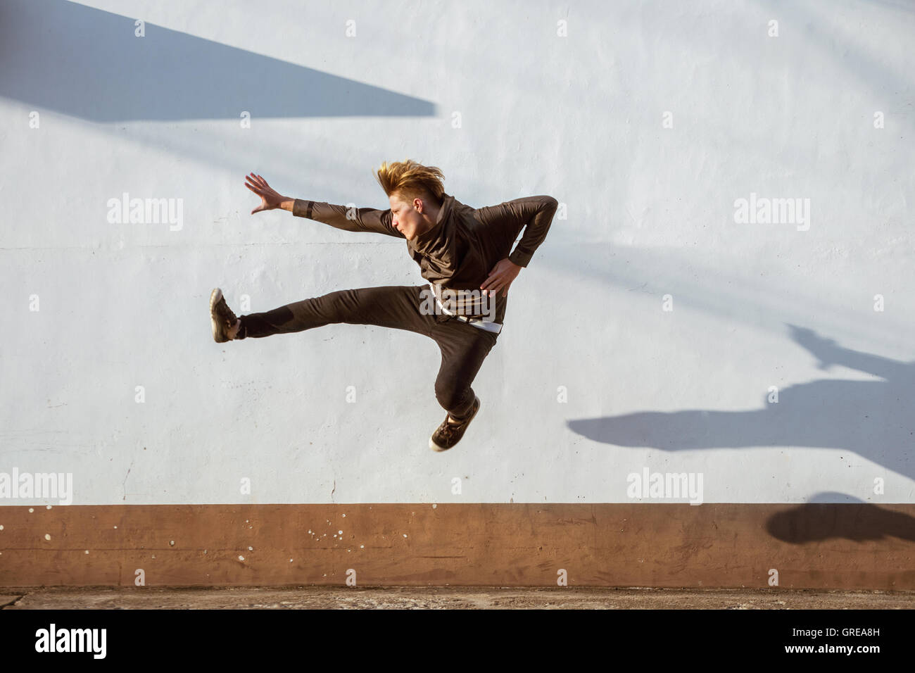 Homme libre jump mur blanc Banque D'Images