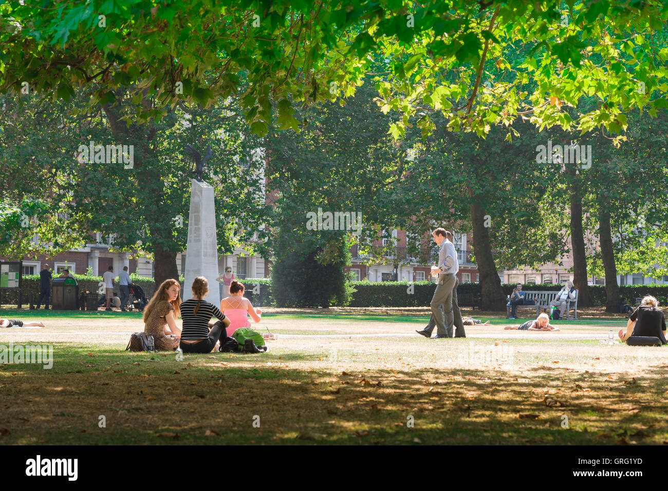 Grosvenor Square Londres, voir de jeunes gens se détendre dans Grosvenor Square par un après-midi d'été, le centre de Londres, Angleterre, Royaume-Uni. Banque D'Images