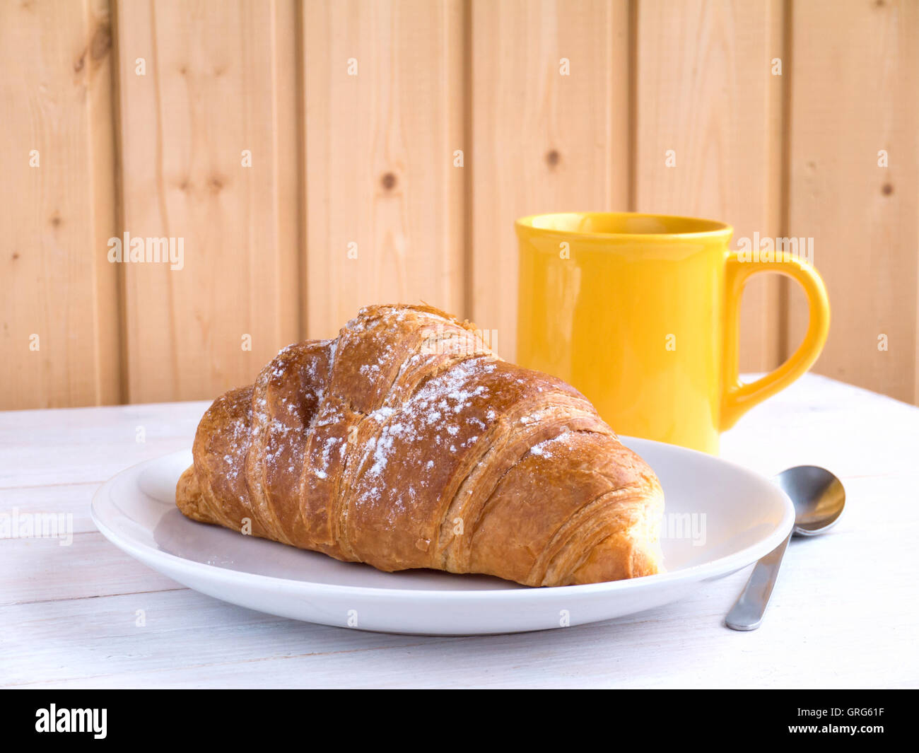 Petit-déjeuner continental et du café croissant dans la tasse jaune sur la table en bois blanc Banque D'Images