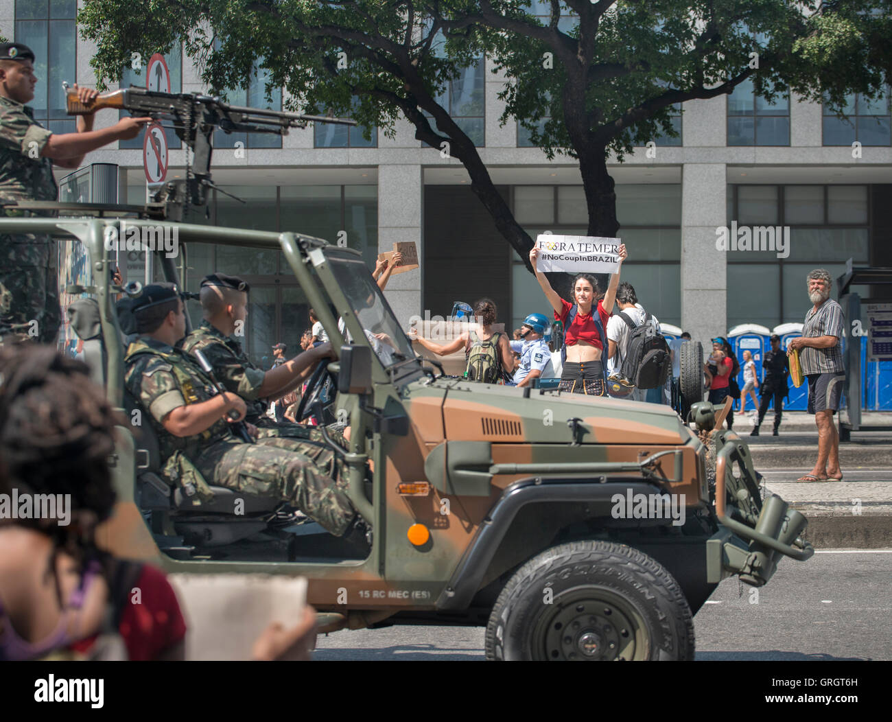 Rio de Janeiro, Rio de Janeiro, Brésil. 7 septembre 2016. Femme détient une bannière contre le président brésilien Michel Temer comme un groupe de trois soldats de l'Armée lourdement armés la regarder et conduire par sur leur véhicule blindé. C'était pendant le défilé de l'Indépendance brésilienne à Rio de Janeiro. Credit : Ellen Pabst dos Reis/Alamy Live News Banque D'Images