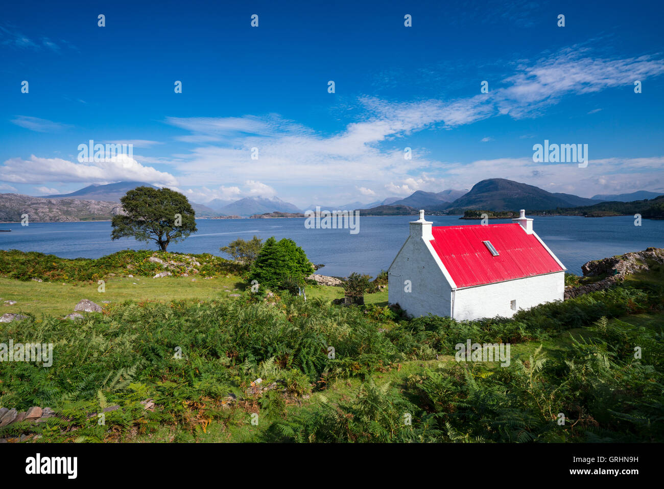 Petite maison blanche au toit rouge au bord du Loch Shieldaig dans Torridon, sur la côte nord 500 route touristique, Highland, Scotland Banque D'Images