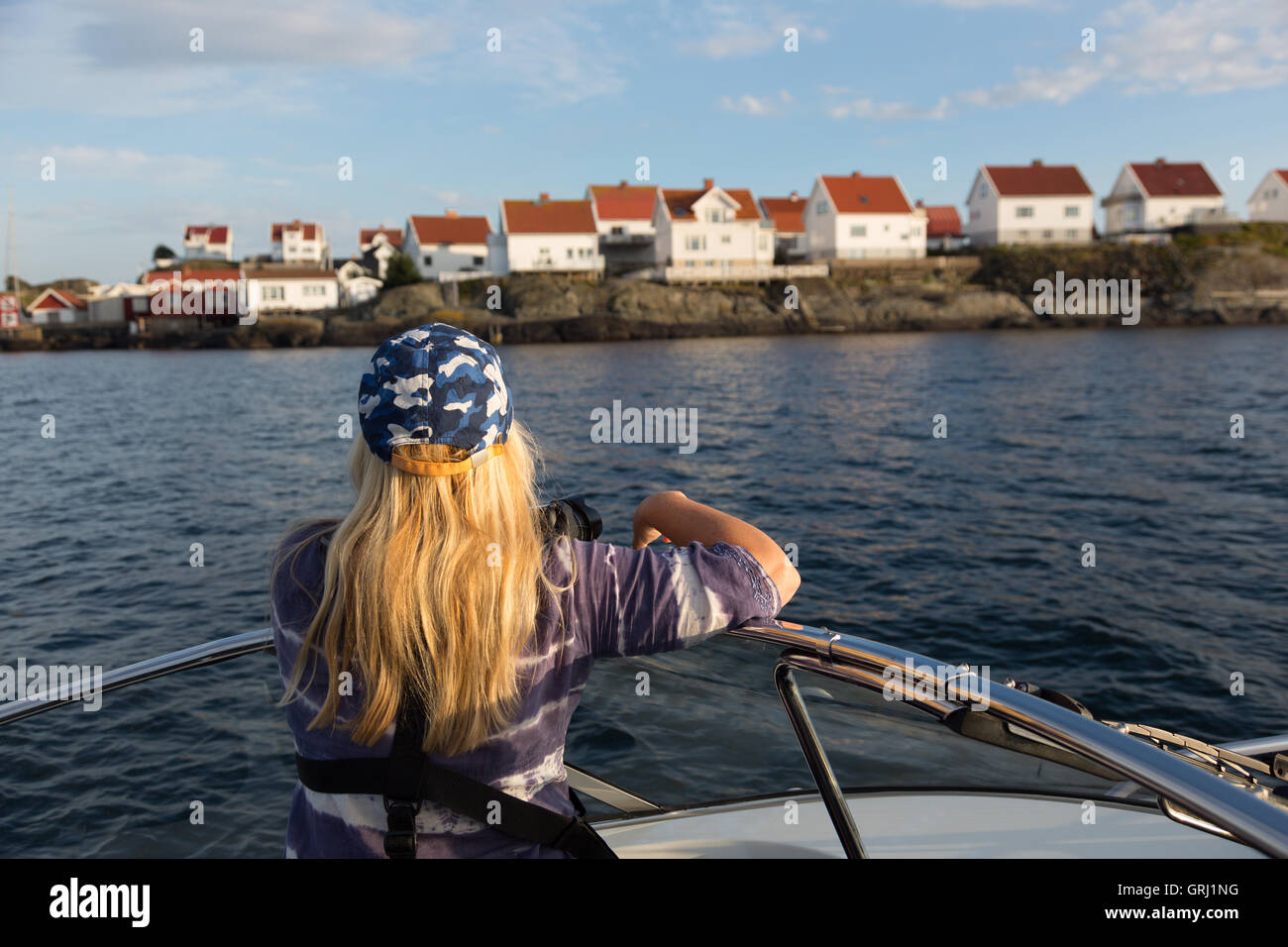 En bateau à l'extérieur de l'île Astol au fjord Marstrand en Suède Côte Ouest. Dame est à regarder les maisons sur l'île. Banque D'Images