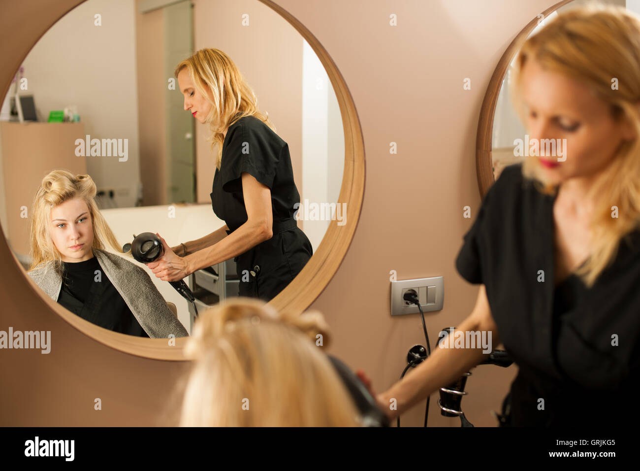 Coiffeur professionnel au travail - coiffure coiffure faisant de belle jeune blonde client dans un studio professionnel Banque D'Images