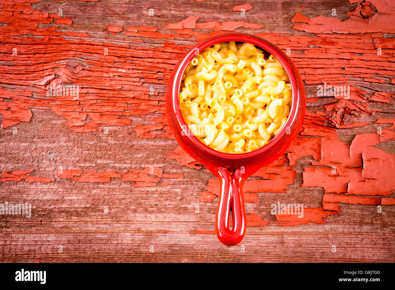 Mini macaroni au fromage servi en pot de terre cuite émaillée rouge sur la table de pique-nique rustique Banque D'Images