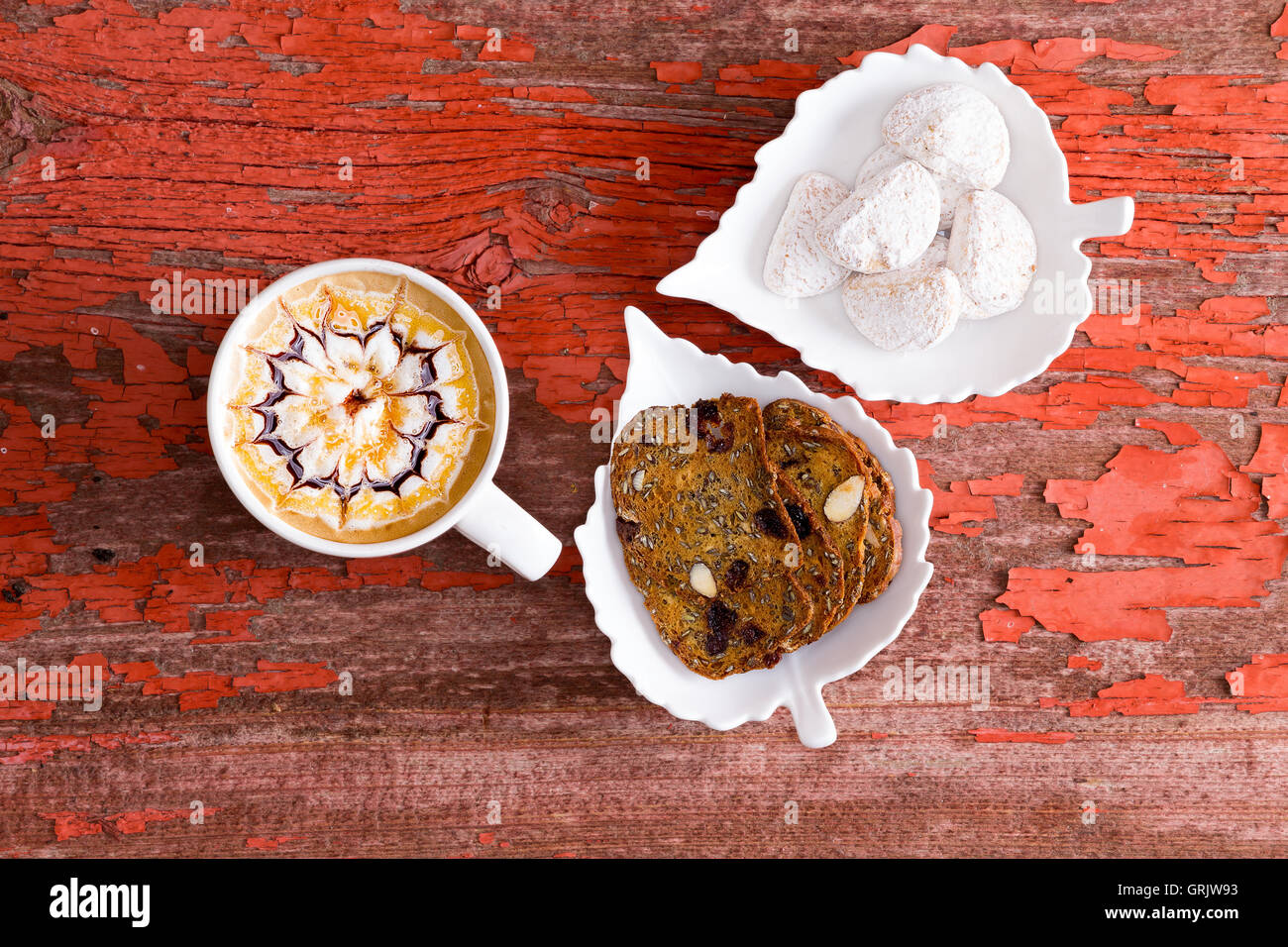 Chocolat caramel latte avec un modèle artistique dans la mousse servi avec du pain croustillant de noix et amandes enrobés de sucre cook wedge Banque D'Images