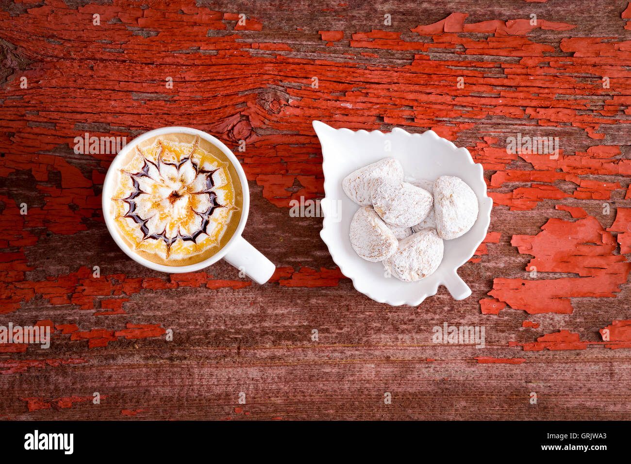 Tasse de chocolat caramel délicieux latte avec une machine à expresso et d'un motif décoratif sur la mousse servi avec une en forme de feuille Banque D'Images