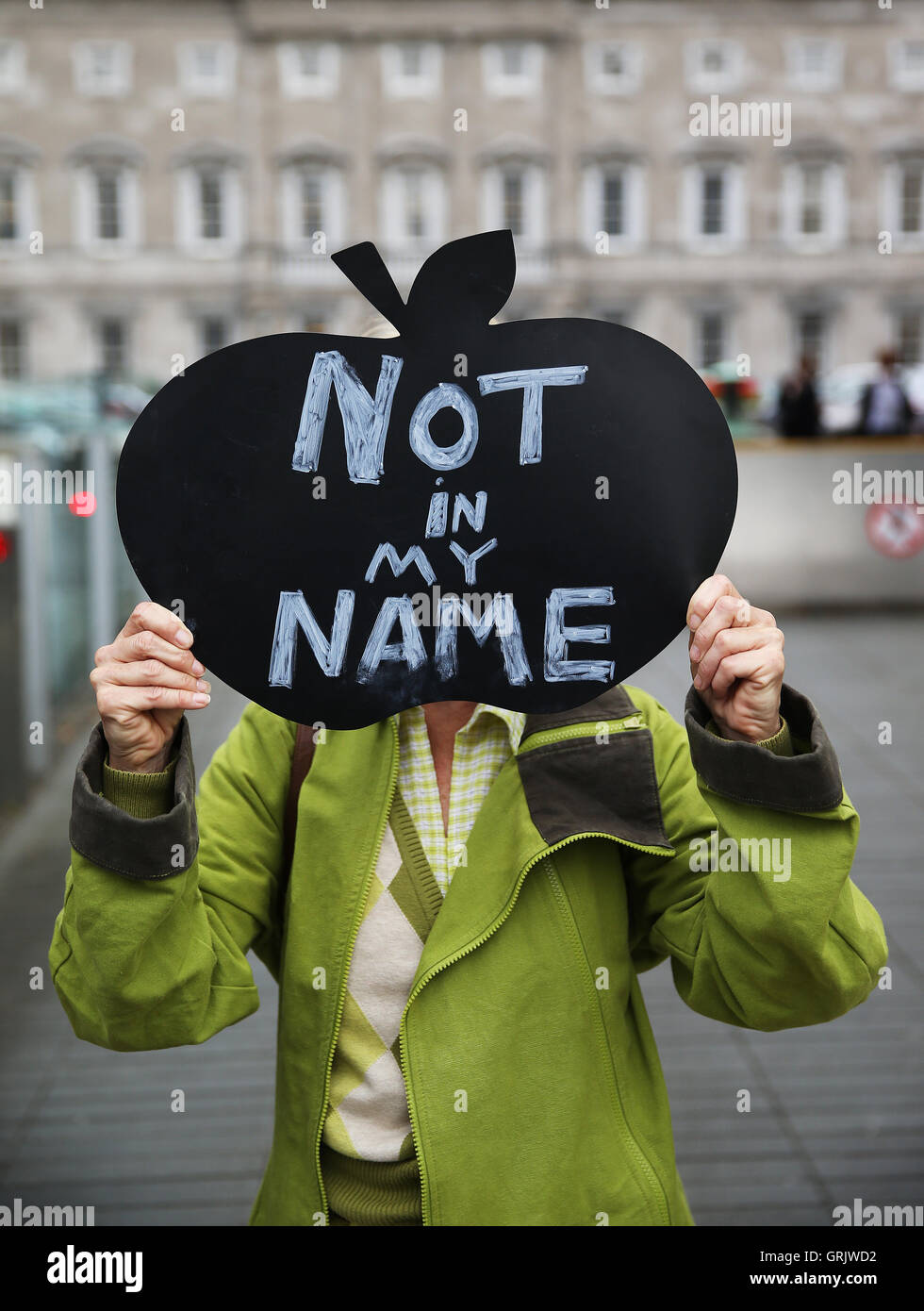 Un manifestant est titulaire d'un signe extérieur de Leinster House à Dublin comme la chambre des députés a été rappelé pour entendre les débats sur l'appel prévu à l'encontre de la décision de la Commission européenne qu'Apple doit payer 13 milliards d'euros en retour d'impôts. Banque D'Images