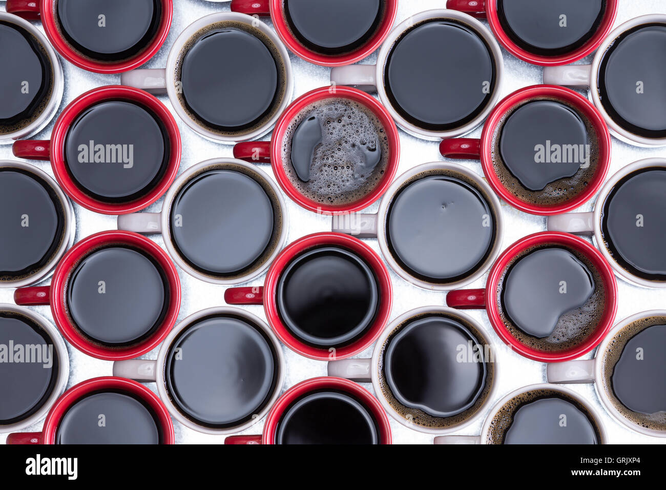 Motif décoratif de café noir en rouge et blanc, café, disposées en rangées alternées avec toutes les poignées vers la gauche sur Banque D'Images