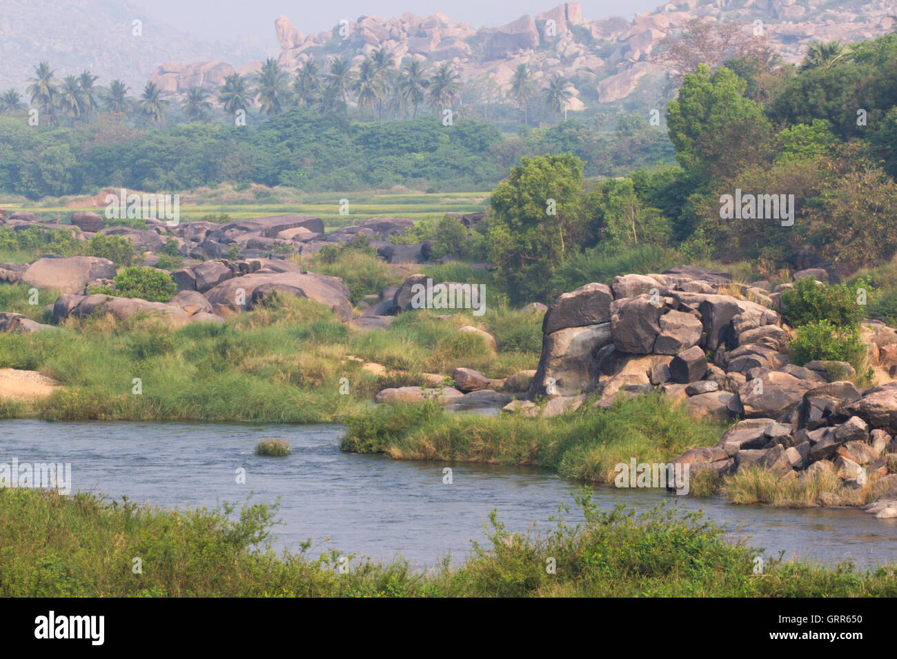 Village de Hampi Tungabhadra river meadow. Paysage avec de l'eau, palm, rock, des pierres. L'Inde, Karnataka Banque D'Images