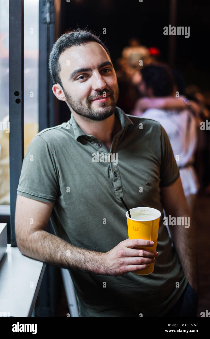 L'Homme barbu beau coctail potable ou de la bière en plein air au Café de la rue la nuit de la partie in park Banque D'Images