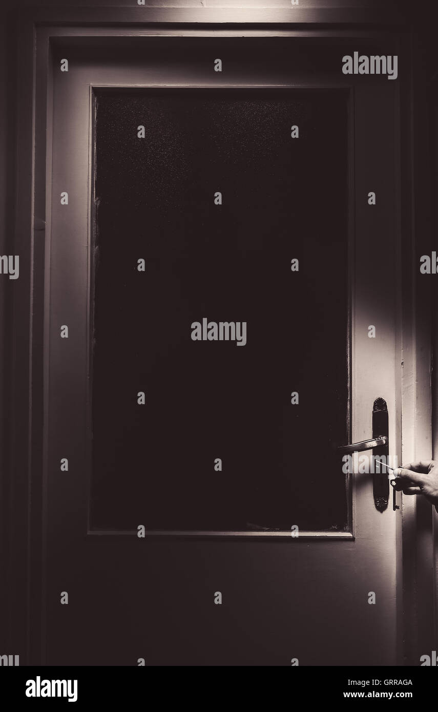 Juste une vieille maison avec porte de verre dans le milieu, homme part avec la touche en plus de poignée de porte. Banque D'Images