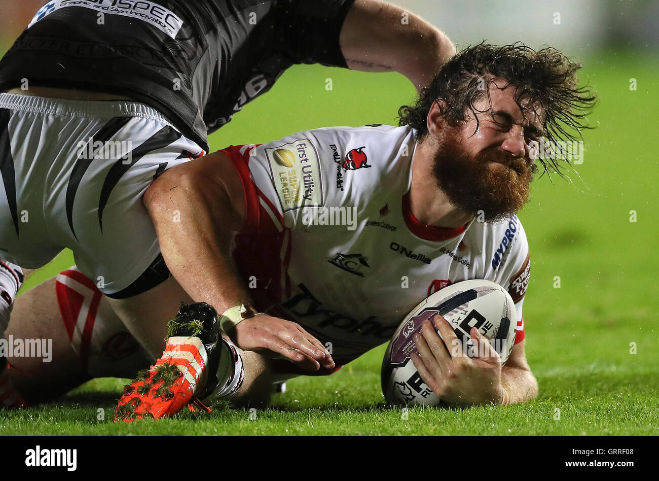 St Helens' Kyle Amor est abordé par Castleford Tigers' Paddy Flynn, au cours de la Première Ligue Super Utilitaire Super 8'S match à Langtree Park, St Helens. Banque D'Images