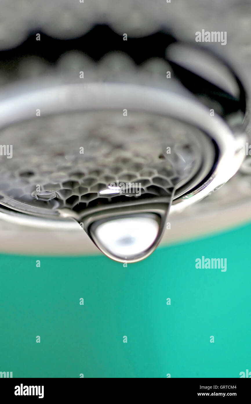 Une macro d'un robinet robinet blanc / dégoulinant de fond bleu. Banque D'Images