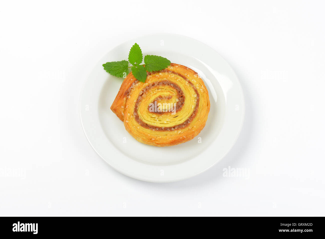 Sweet cinnamon roll on white plate Banque D'Images