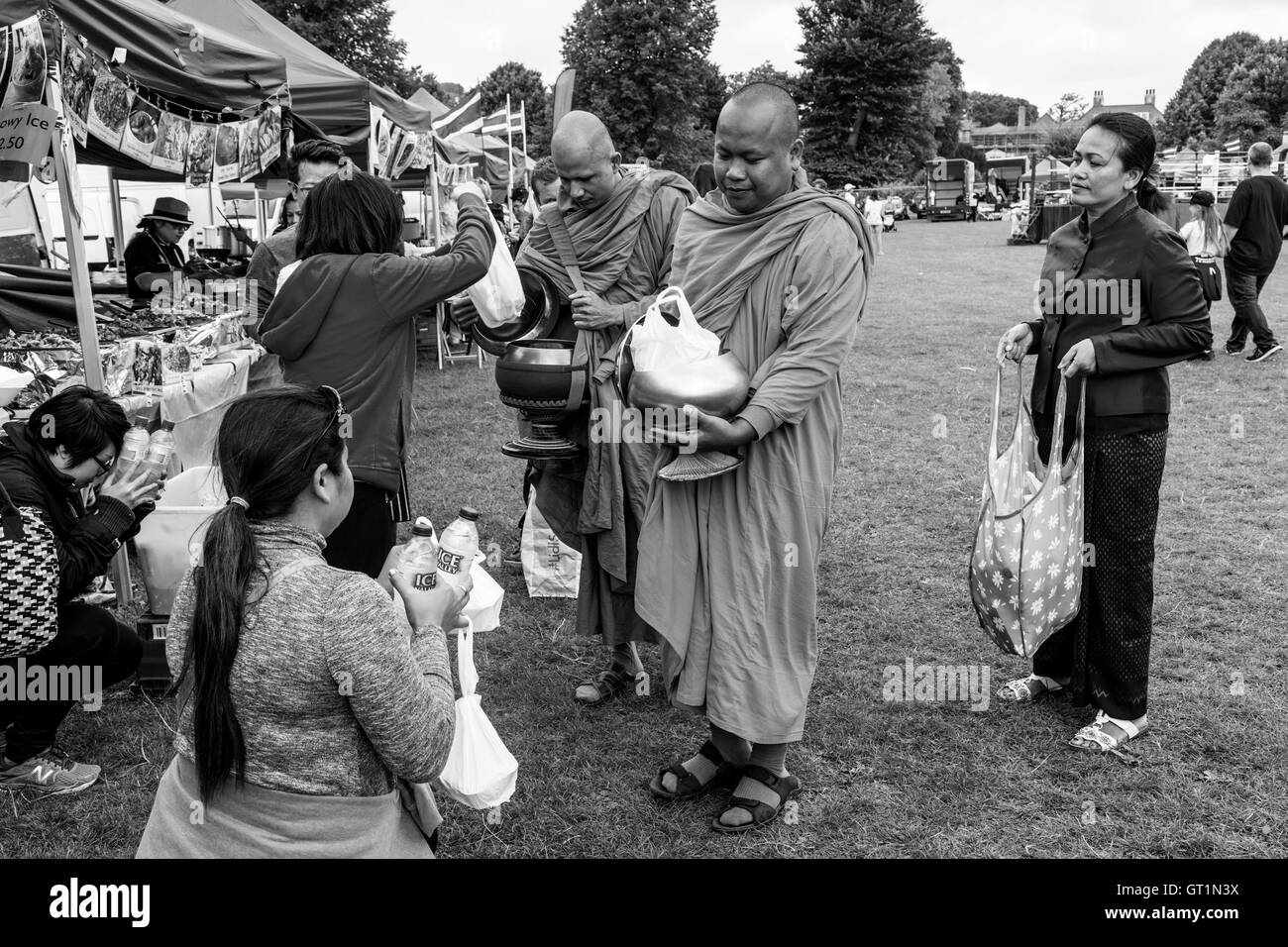 Les thaïlandais offrent des aliments à deux moines du Brighton Festival thaïlandais, Preston Park, Brighton, Sussex, UK Banque D'Images