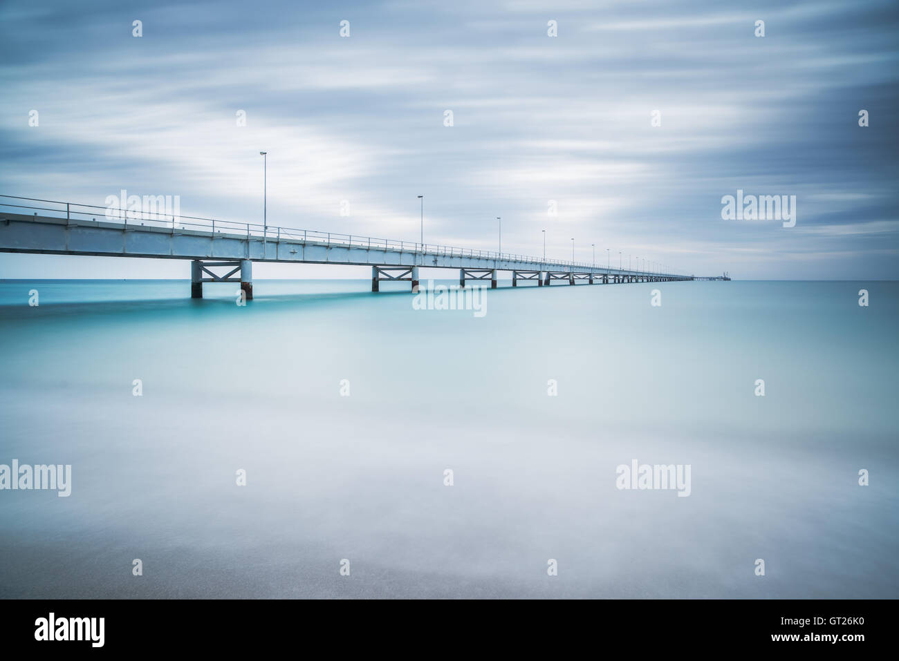 Sur le quai industriel horizon de mer. Vue de côté. Photos à longue exposition dans un jour nuageux. Banque D'Images