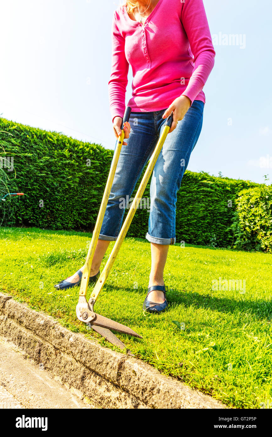 Couper l'herbe avec longue poignée cisailles cisailles à bord de coupe en bordure jardinier jardinage femme coupe couverture UK Angleterre GO Banque D'Images