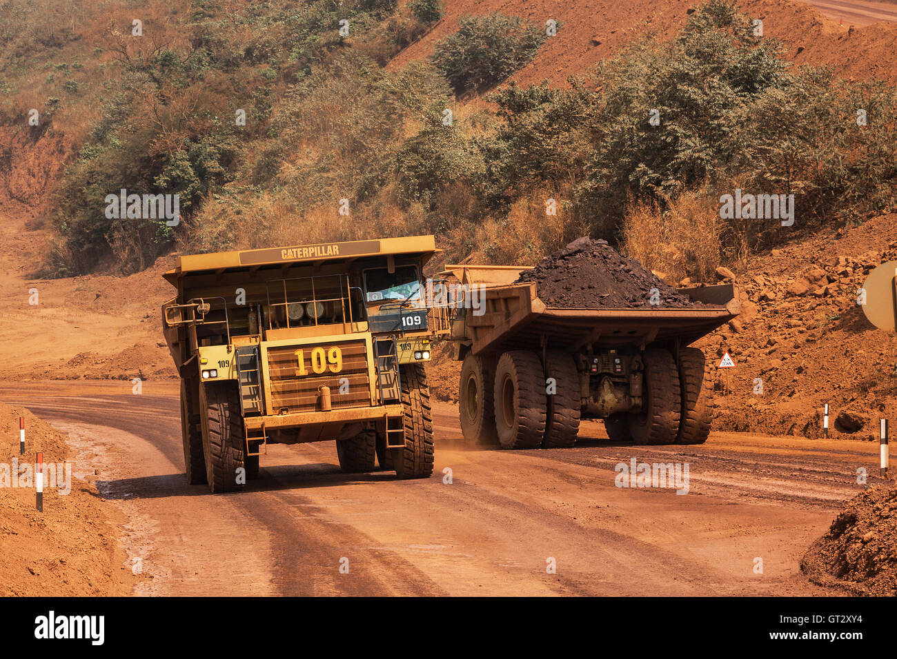 Opération minière pour le transport et la gestion de minerai de fer. Dump de camions de transport sur route de la mine et de fosse. Quand il est chargé de retourner au corps minéralisé avec concasseur Banque D'Images